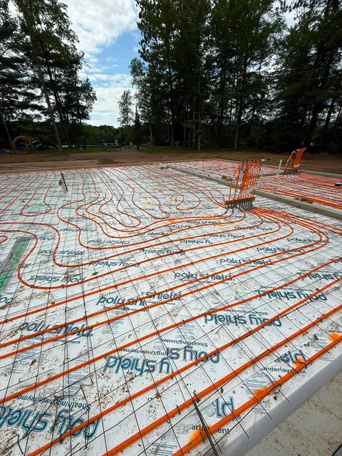 Orange radiant floor tubing laid over PolyShield-faced EPS insulation